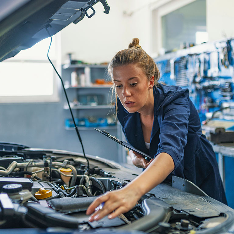 female mechanic working on car engine